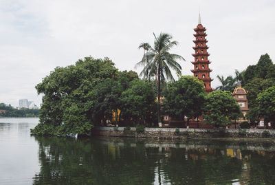 Temple by lake against sky