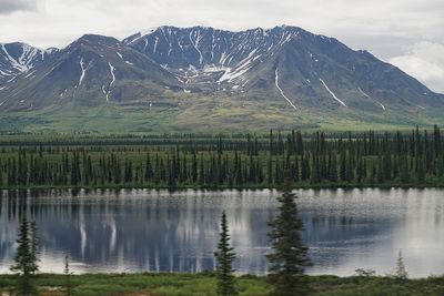 Scenic view of lake by mountains against sky