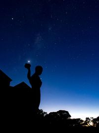 Silhouette man standing against star field at night