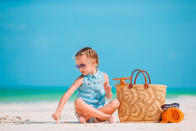 Full length of baby girl at beach against clear blue sky