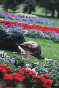 Portrait of woman lying on flowering plants