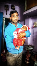Portrait of young man standing against wall