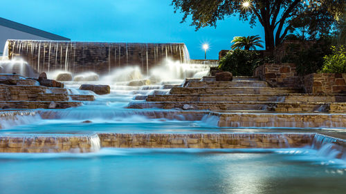 Water fountain in swimming pool against sky