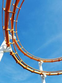 Low angle view of rollercoaster against blue sky