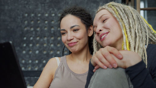 Portrait of smiling young woman using smart phone outdoors