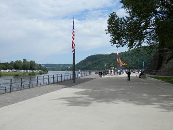 People walking on pathway by lake