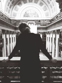 Rear view of woman standing in corridor
