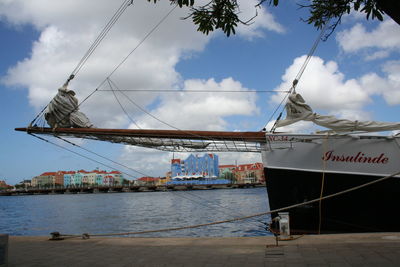 Ship moored at harbor against sky