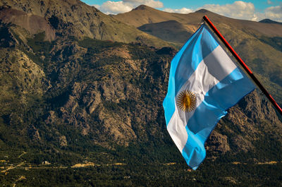 Low angle view of flag against mountain range