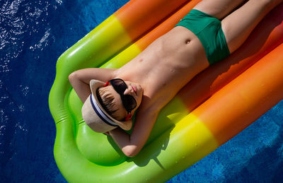 Boy in a straw hat swims in the pool on an inflatable mattress. bright juicy summer photo