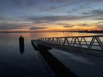 Pier on sea against sky during sunset