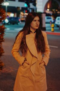 Beautiful woman wearing overcoat on street at night