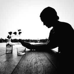 Side view of silhouette man looking at table