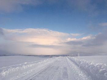 Snow covered landscape against sky