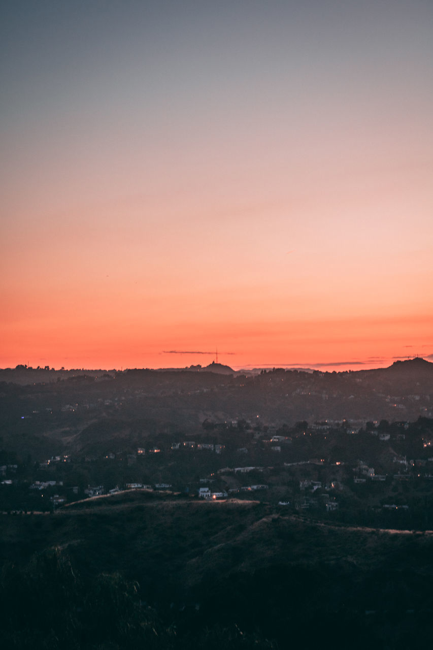 HIGH ANGLE VIEW OF SILHOUETTE LANDSCAPE AGAINST CLEAR SKY AT SUNSET