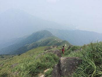 Rear view of man on mountain against sky