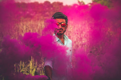 Portrait of young man wearing multi colored standing outdoors