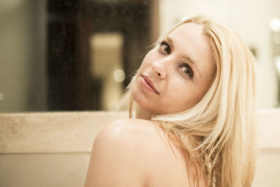 Side view portrait of young woman by mirror