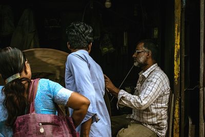 Rear view of people sitting in temple