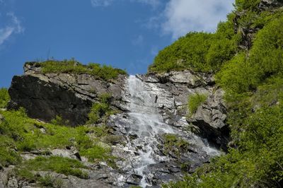 Scenic view of waterfall against sky