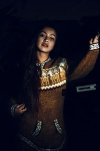 Portrait of young woman standing outdoors at night