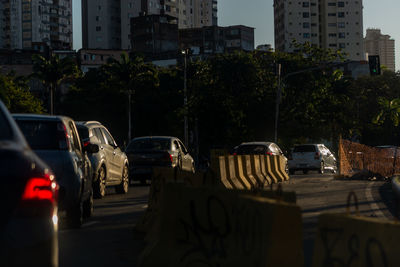 Cars on city street by buildings