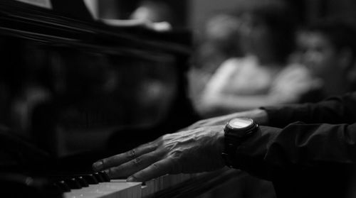Side view of hands playing the piano
