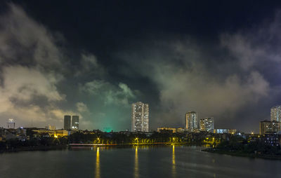 Illuminated buildings in city against sky at night