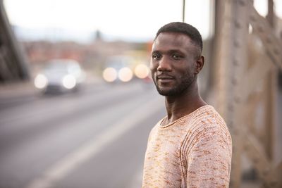 Portrait of young man standing in city