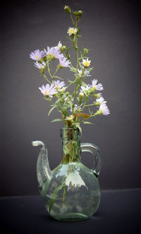 Close-up of white flower vase on table against black background