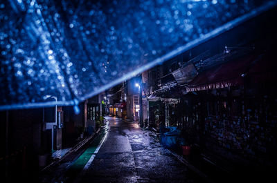 Empty road amidst buildings in city during rainy season