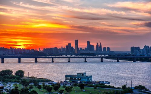 Scenic view of city buildings against sky during sunset