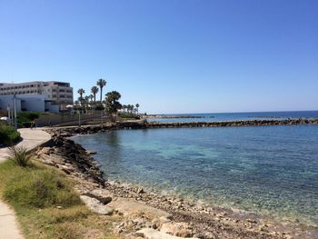 Calm sea against clear blue sky