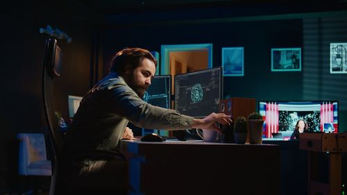 Side view of man using laptop at home