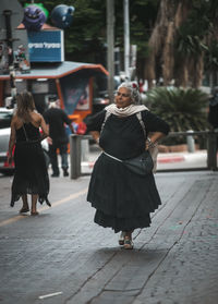 Rear view of women standing on footpath