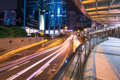 Light trails on road amidst buildings in city at night