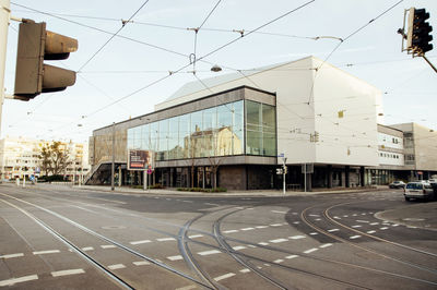 Railroad tracks by buildings in city against sky