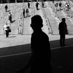 Rear view of people walking on the road