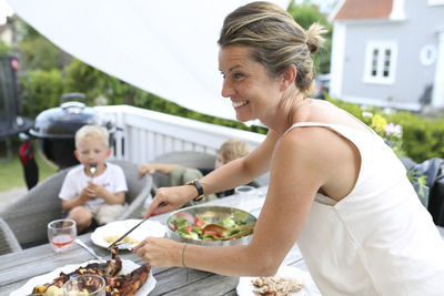 Smiling woman preparing meal in garden