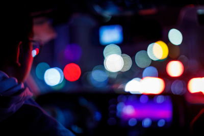 Close-up of woman with illuminated lights at night