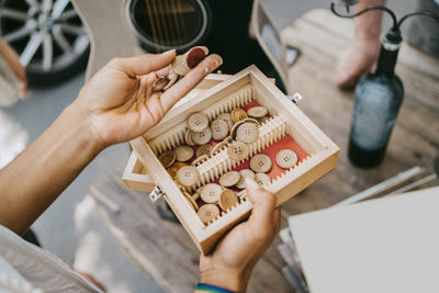 High angle view of woman holding container of buttons at flea market