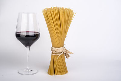 Close-up of wineglass on table against white background