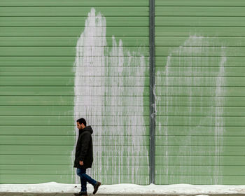 Side view of woman standing against wall