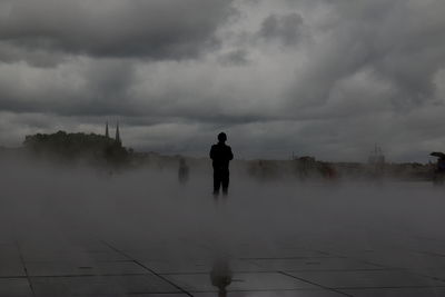 Man standing on water against sky