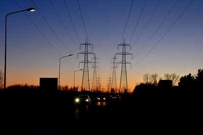 Silhouette of electricity pylon at sunset