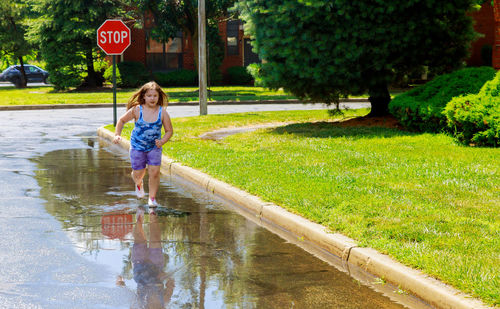 Full length of girl running on puddle