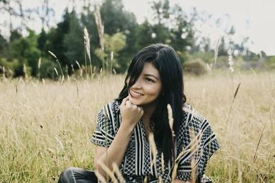 Young woman smiling while standing on field