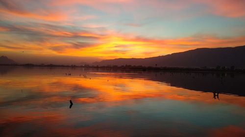 Scenic view of lake against orange sky