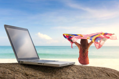 Low angle view of person using mobile phone on beach