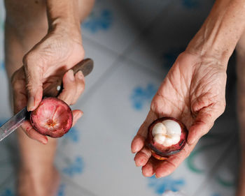 Midsection of man holding fruit